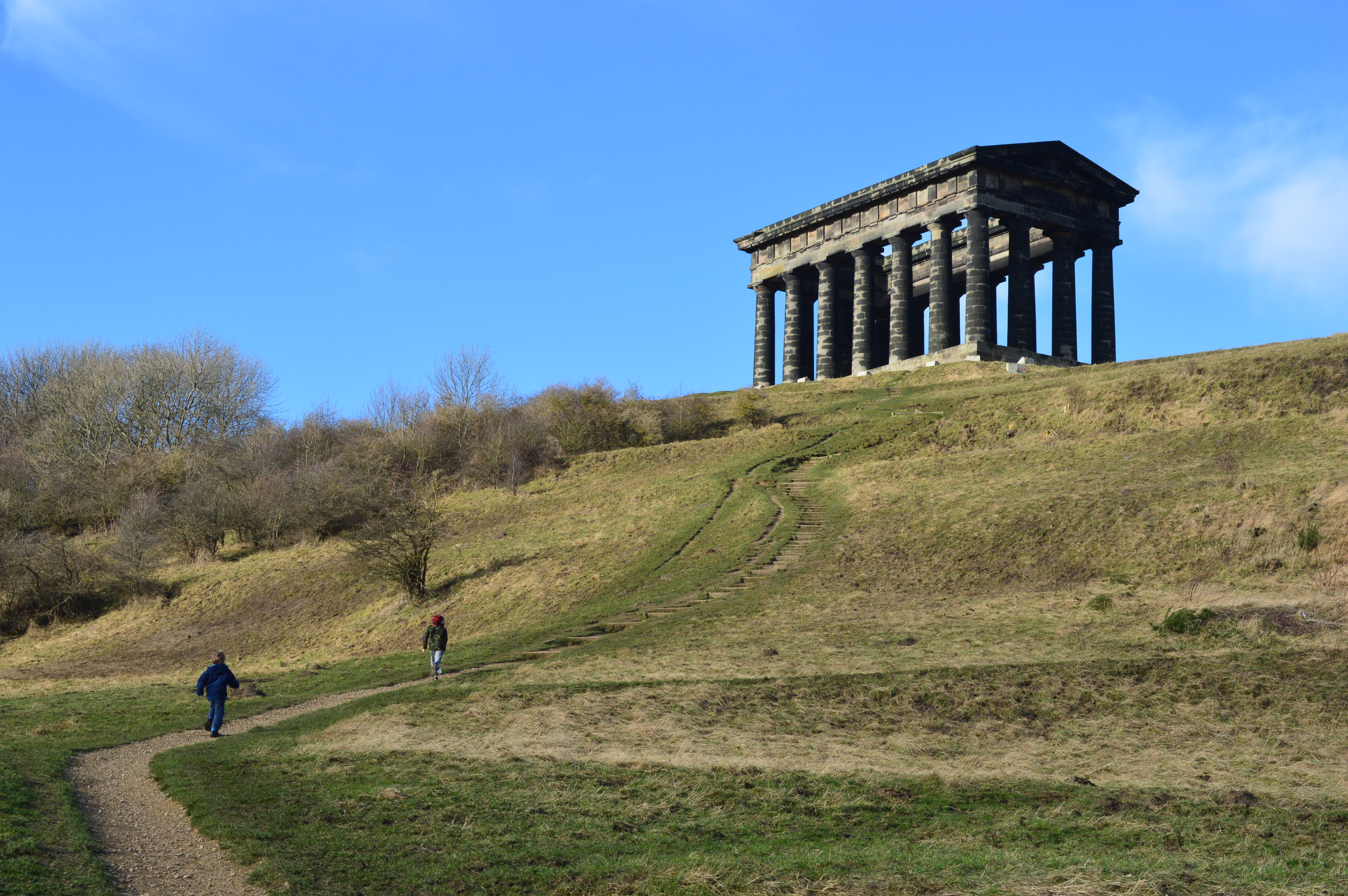 people running up a hill toward a monument